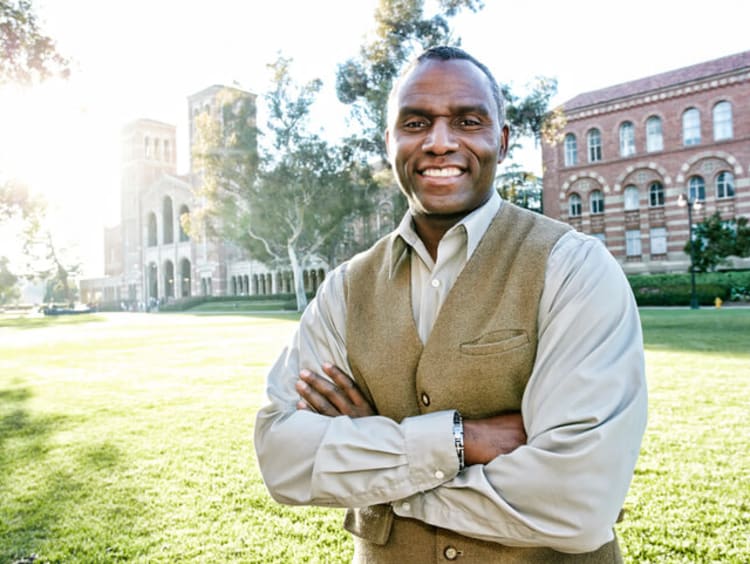 male EdS professor smiling outside of school building