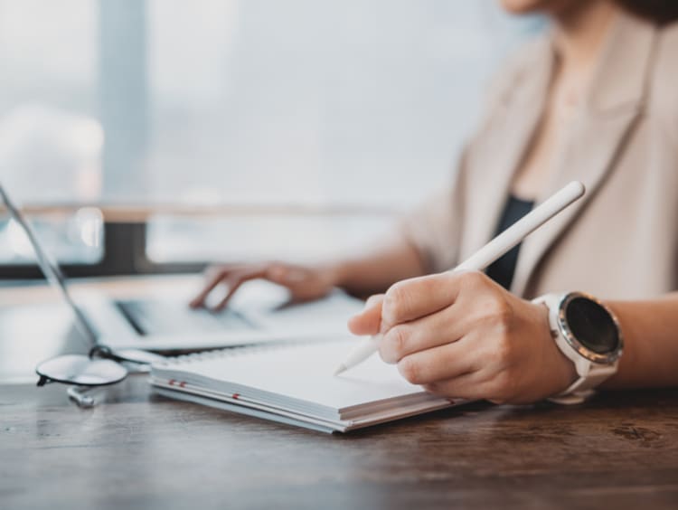 Woman writing a conference paper on her laptop