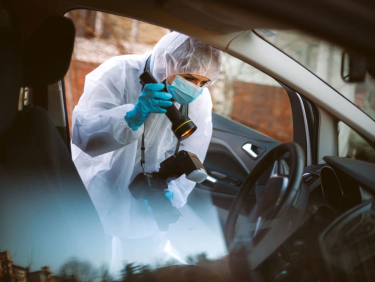 A forensic scientist takes pictures at a crime scene