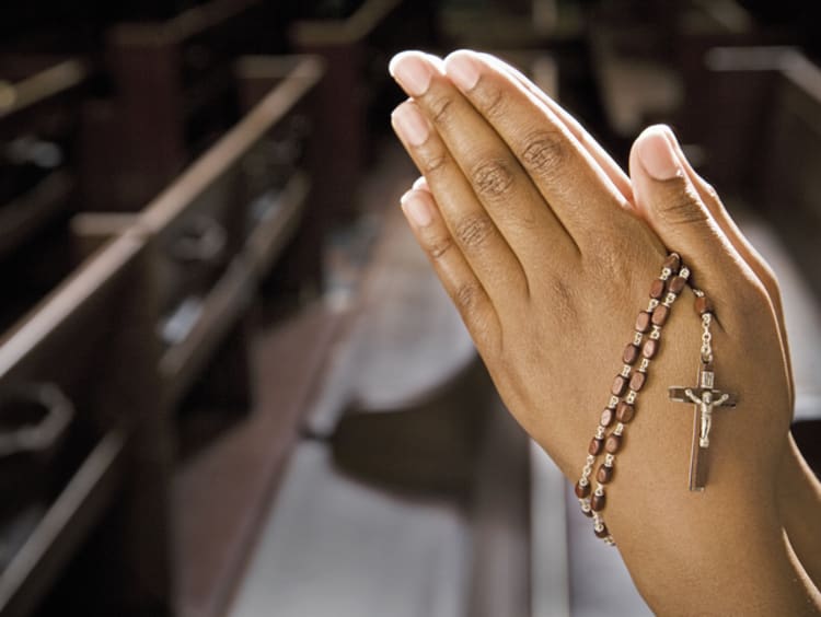 Female praying with her crucifix