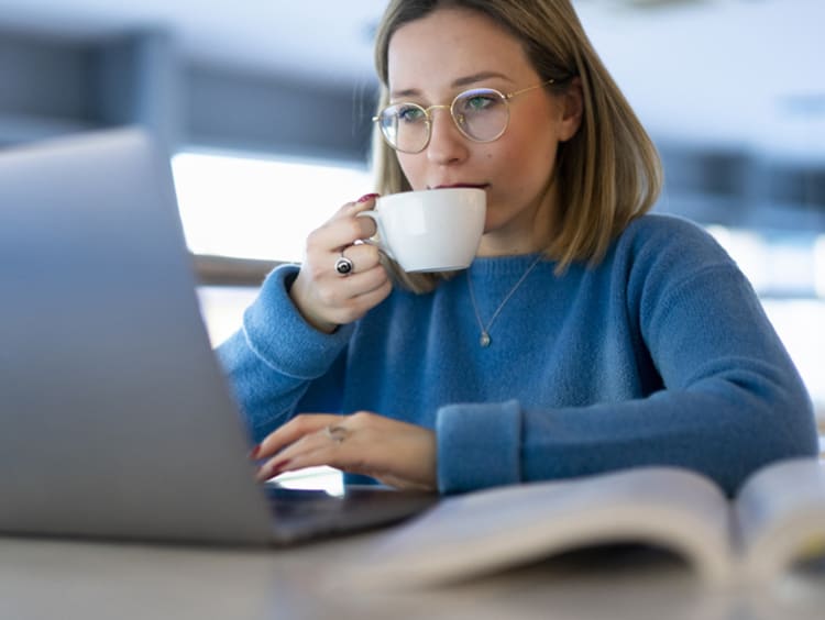 Student focusing on homework while drinking tea