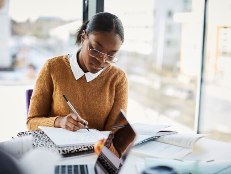 Adult student studying her notes at a table