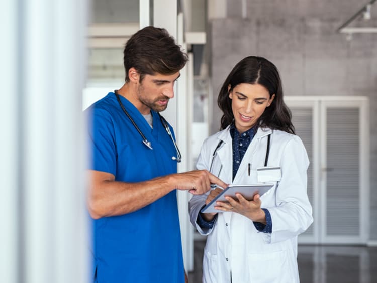 Male and female orthopedists discussing test results in hospital