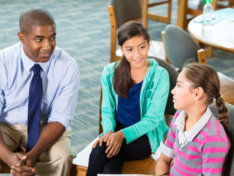 two teachers talking with a student who has been bullied