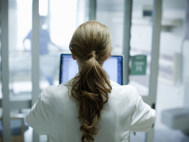 Doctor working with health informatics on laptop