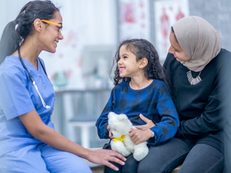 Female FNP talking with young patient and her mom in office