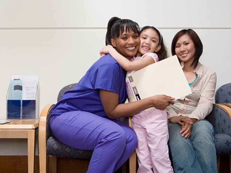 Little girl happily hugging family nurse practitioner after appointment