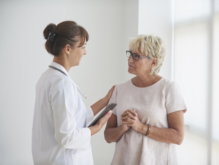Female health communications specialist talking with female patient in office