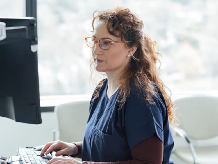 Healthcare professional with MPH degree looking at computer screen