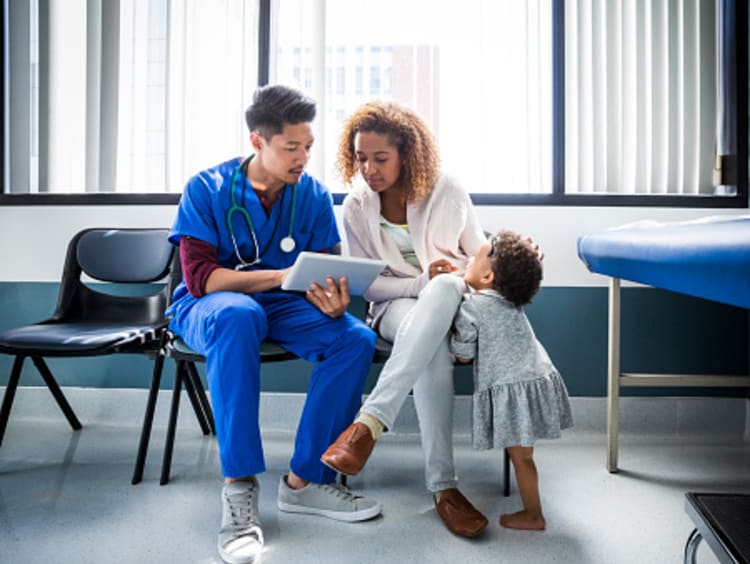 Nurse explaining test results to mother with toddler