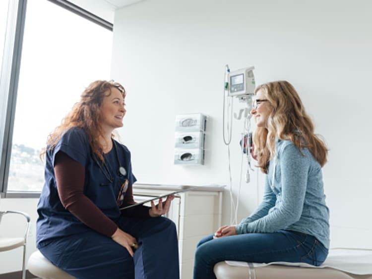 Family nurse practitioner asking teenage patient questions about her health