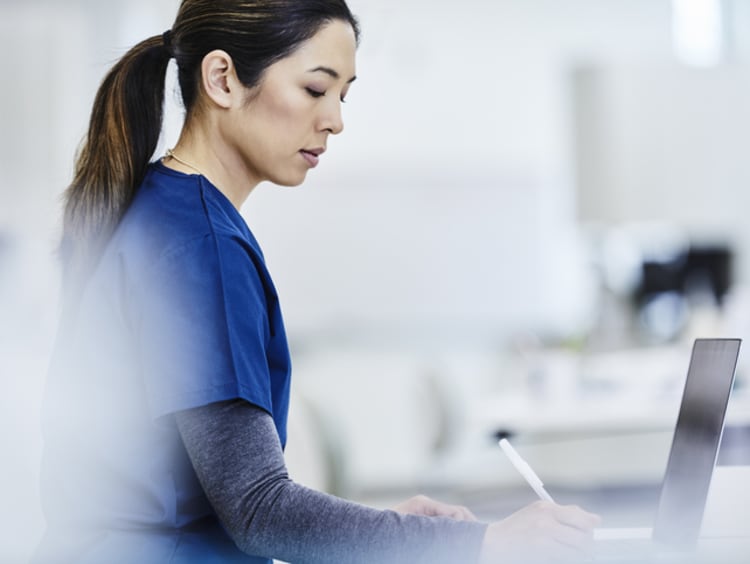 Public health nurse writing down notes in file