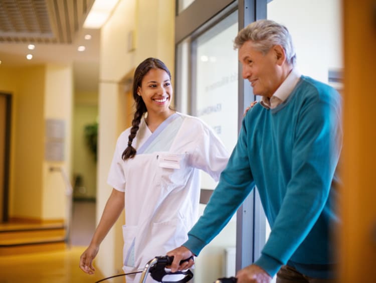 Nurse helping patient walk around hospital safely