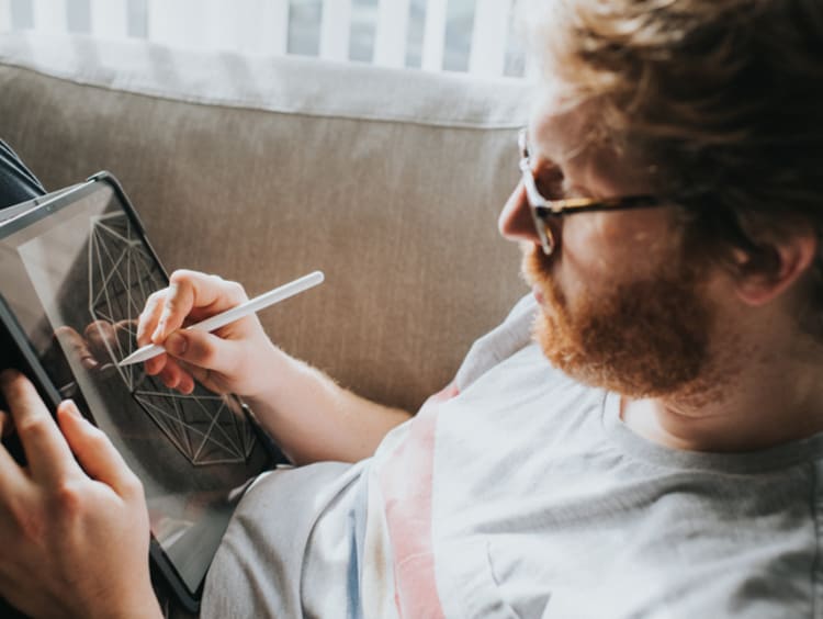 Male artist drawing a digital design on his tablet