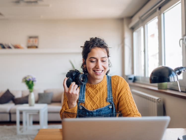 Photographer at home editing photos on laptop