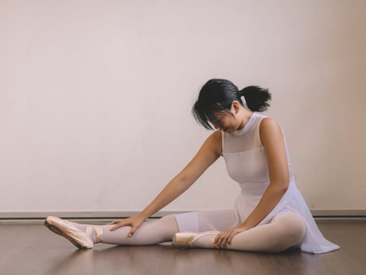 Injured dancer rubbing leg after routine