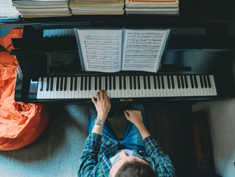 student with music degree playing piano