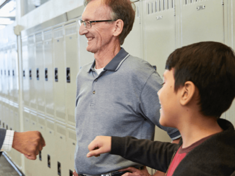 Educational Leader speaks to faculty and students in school hallway setting