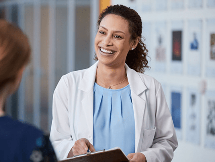 Women's Health Administrator discusses with a patient in clinical setting