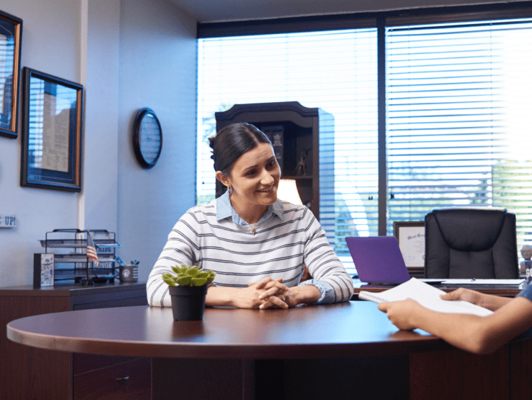 woman principal speaks with boy student