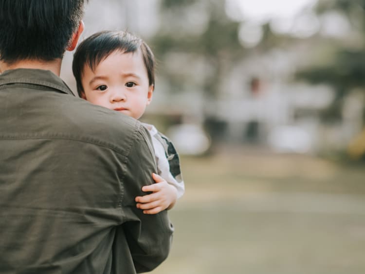 Father carrying Asian baby in his arms