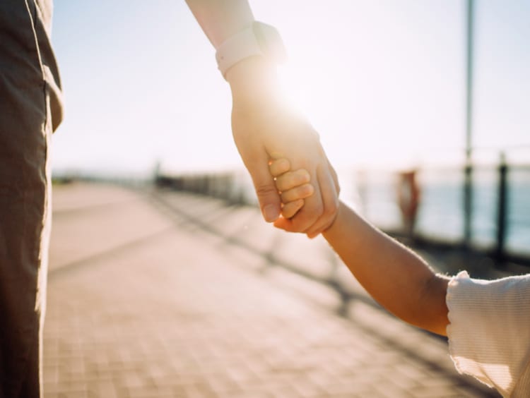 Young child holding parent's hand