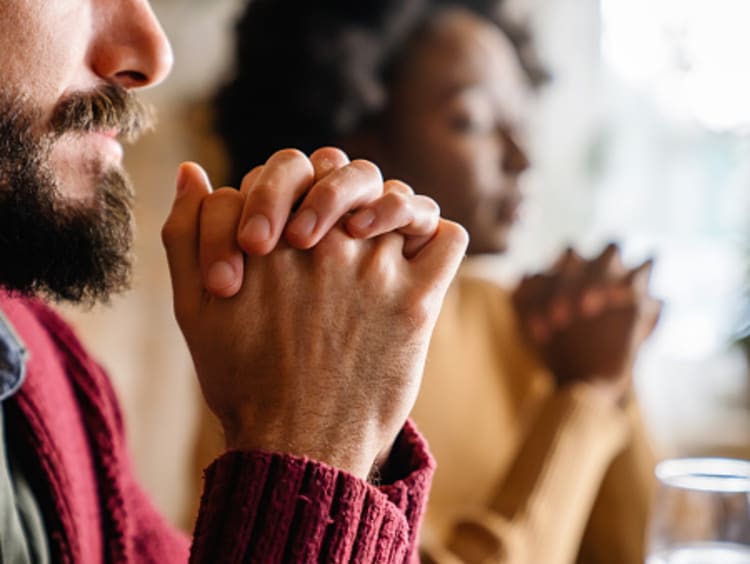 Couple praying before meal as a thankfulness activity