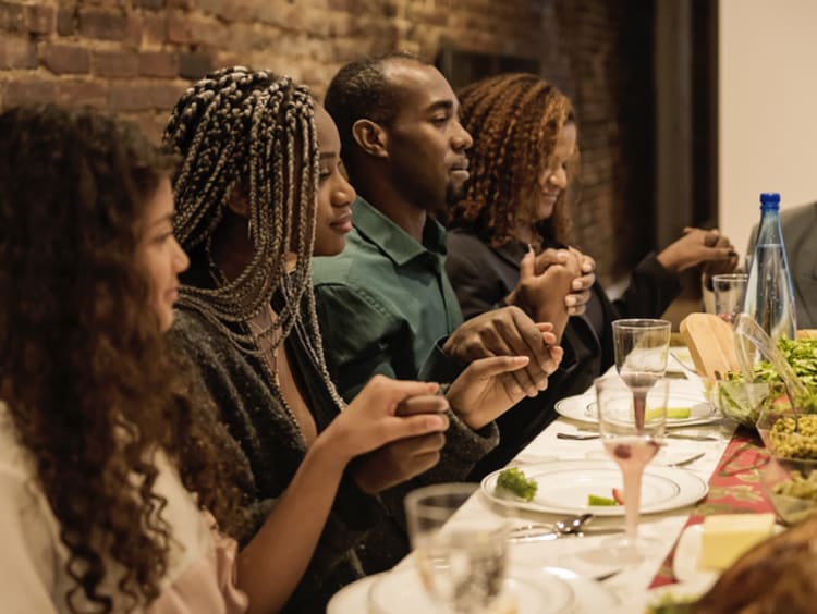 Family giving thanks to God together at the table