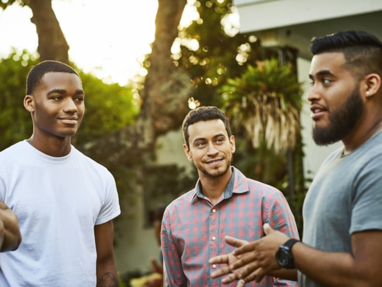 Four men talk with each other