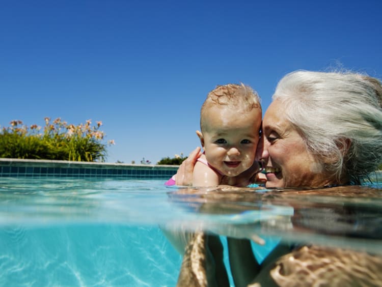 Thankful grandma swimming with baby