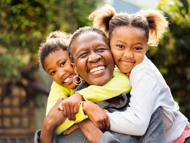 Grandmother and granddaughters showing kindness with group hug