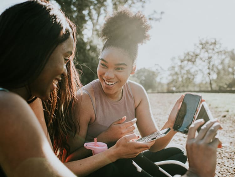 Friends laughing at cell phones demonstrating the power of influence online