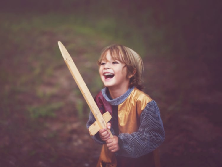 Happy boy with peace in knight costume