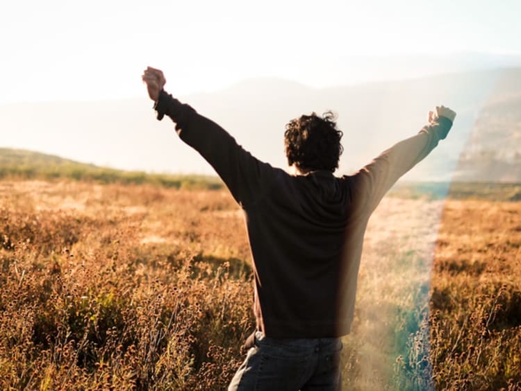 Man celebrating with his hands lifted