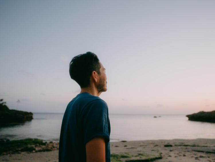 Man looking at the sunset and crying out to God