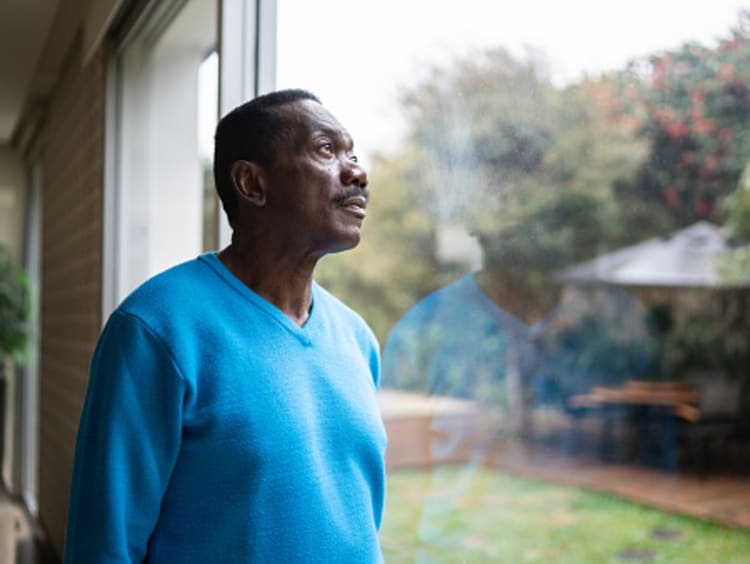 Man looking out the window thinking about the future