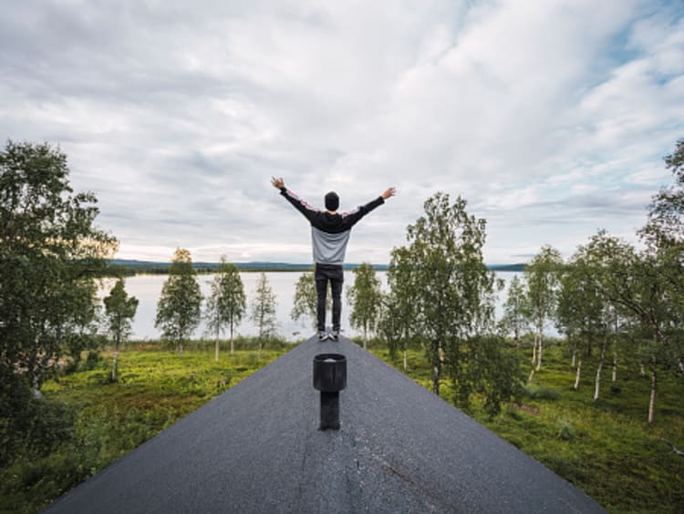 Man standing on roof with hand raised toward Heaven