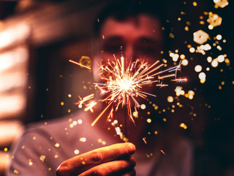 Man holding sparkler on New Year's Eve