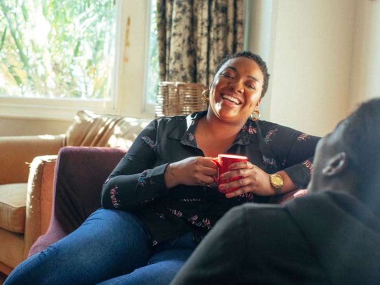 African-American woman having a conversation about faith with friend in a living room