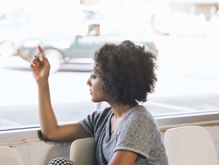 Woman looking out window waiting