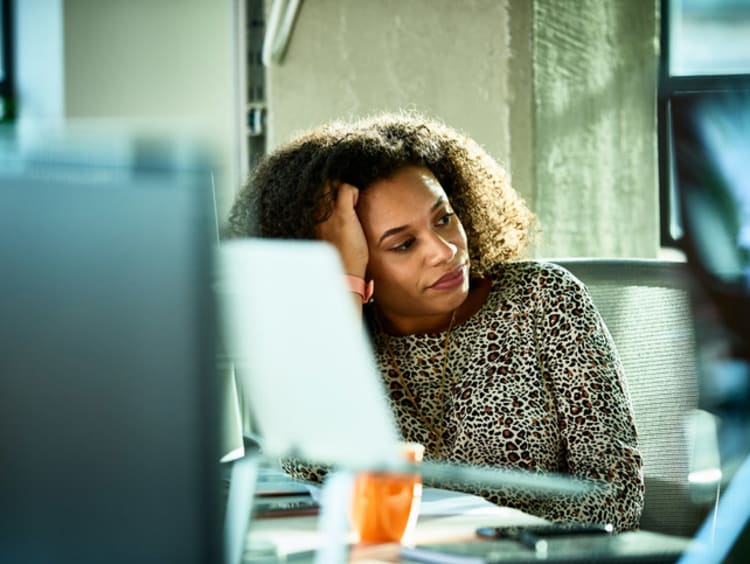 girl sitting at computer resting head against hand