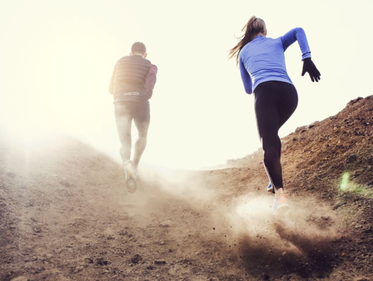 A couple hiking up a dusty mountain