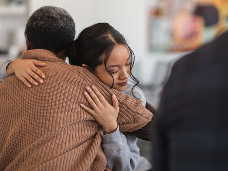 Two women embrace in a hug of forgiveness