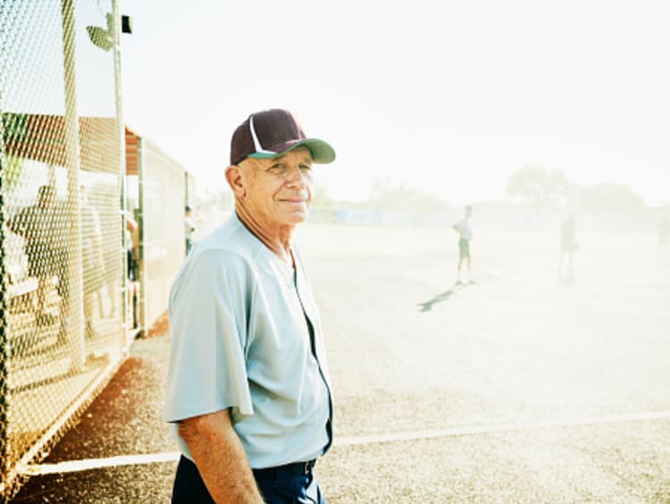 Wise older man standing on baseball field