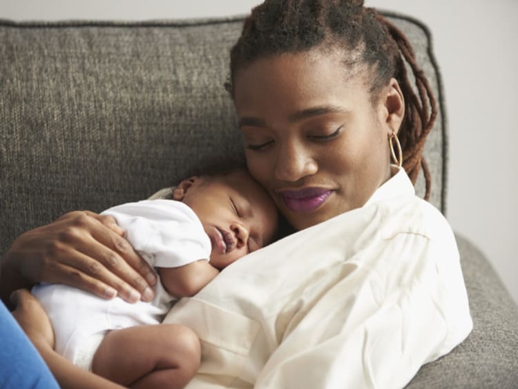 Mother resting with daughter on couch