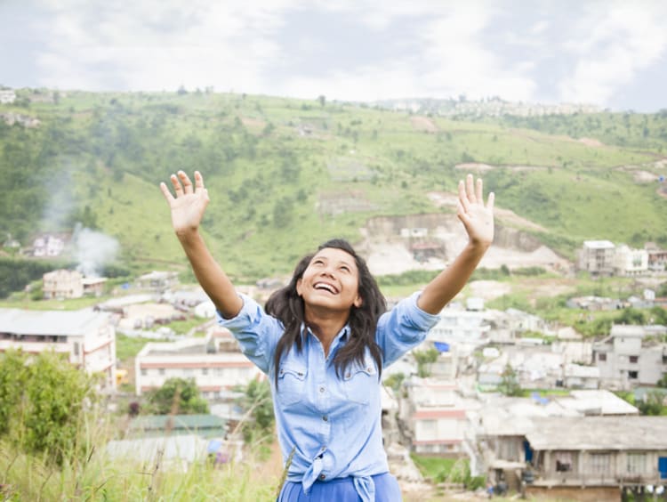 Girl lifting her hands in praise to God