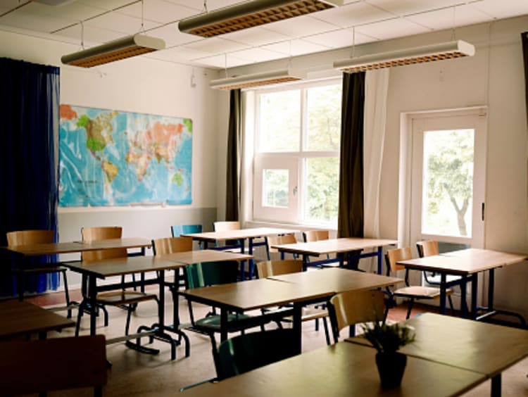 A classroom with desks and chairs 