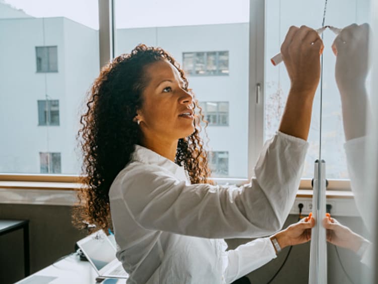 A female vocational teacher writing on a board