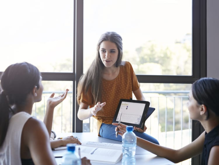 Female teacher working with young adult students in classroom