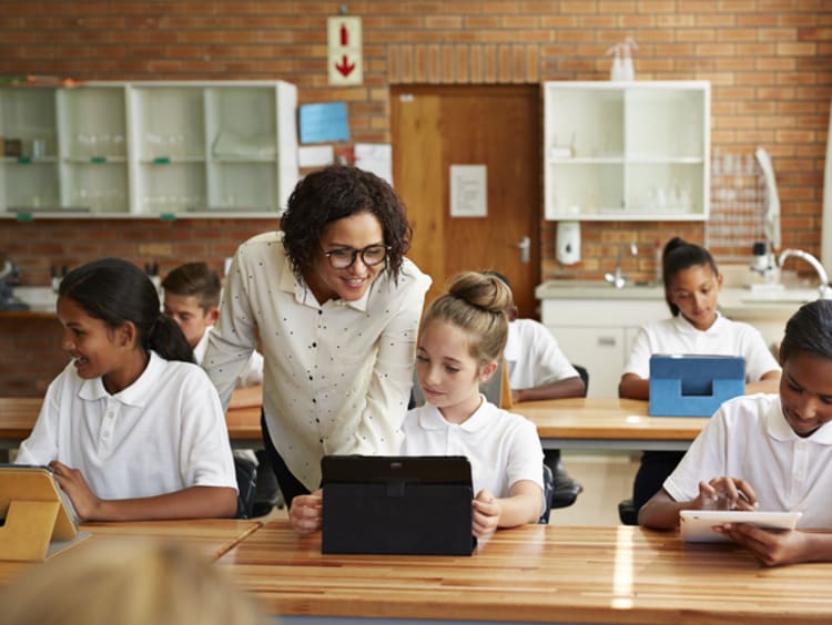 female teacher teaching young students in classroom learning environment